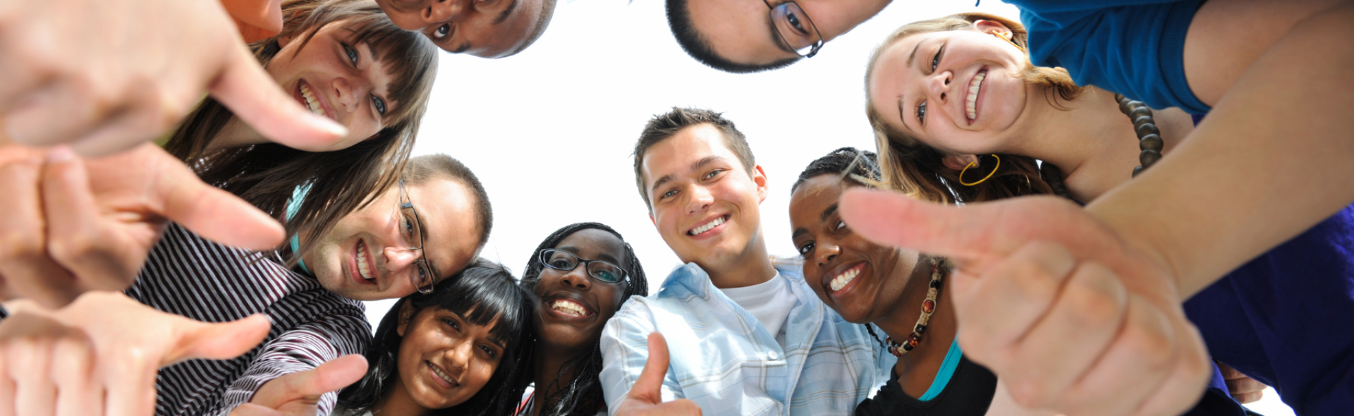 A group of people all smiling and giving a thumbs up
