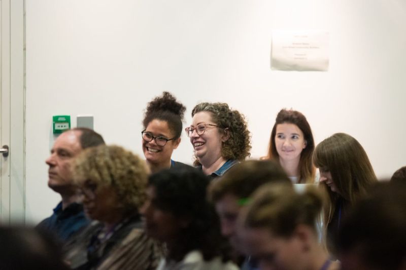 A group of people with 3 women in the centre laughing
